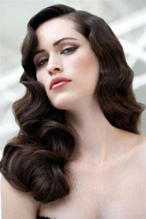 Glam hairstyles - Curl the hair from the bottom layer with a 1½-in (3.81-cm) curling iron. Gather a 1 to 2-inch (2.54 to 5.08-centimeter) wide section of hair. Curl it with a 1½-inch (3.81-centimeter) curling iron, holding the rod horizontally. Hold the iron for a few sections, then release the clamp on the iron.